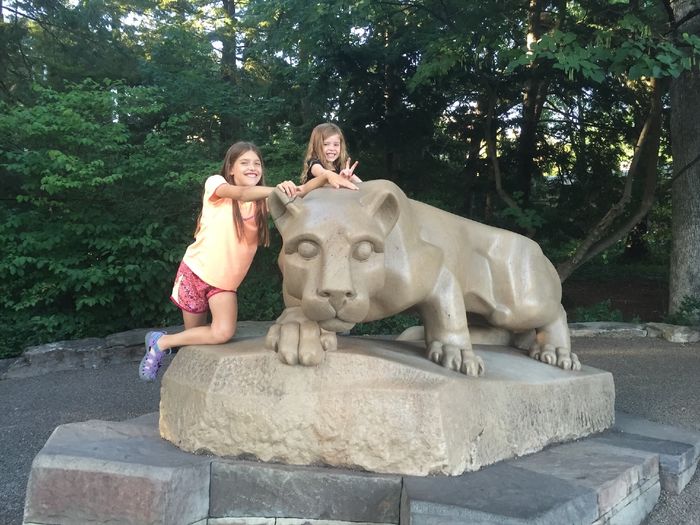 two girls posing with Nittany Lion shrine