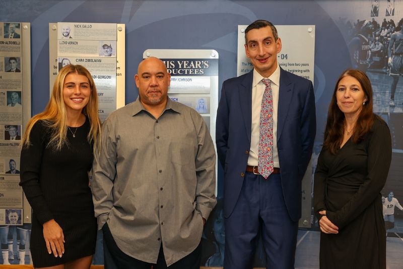 hall of fame inductees standing in front of hall of fame wall