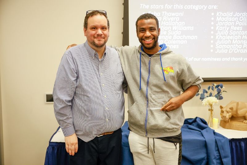student and staff member with award