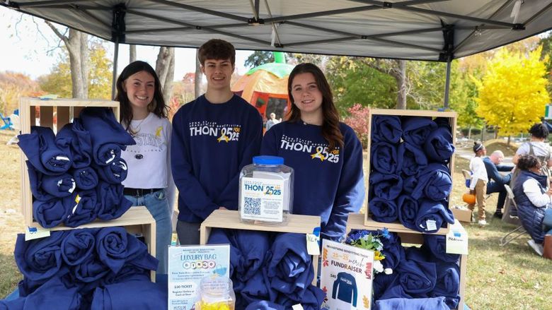 students selling THON sweatshirts