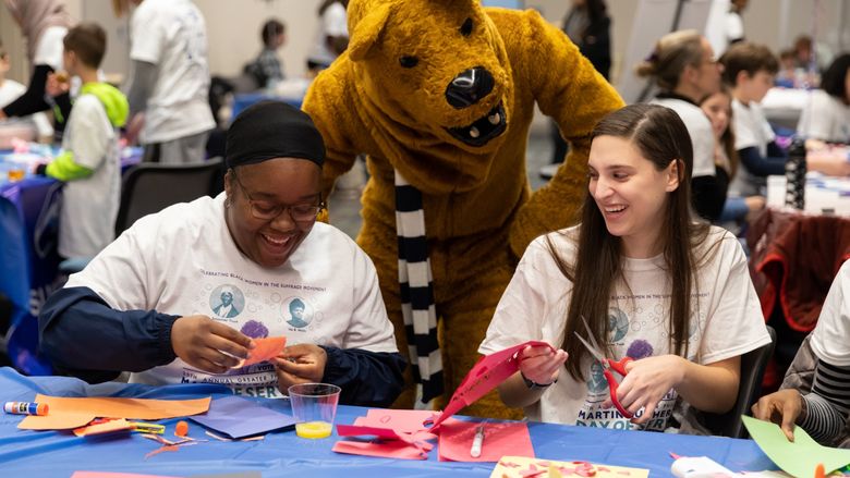 Two Penn State Brandywine students celebrating MLK Day with the Nittany Lion. 
