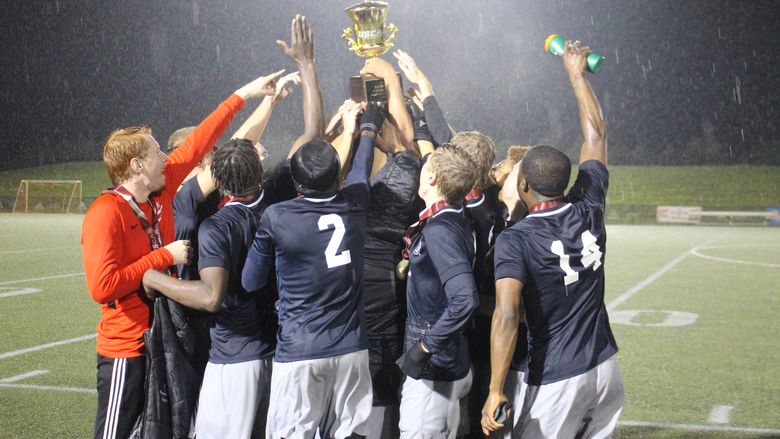 Brandywine men's soccer players raise the team's championship trophy.