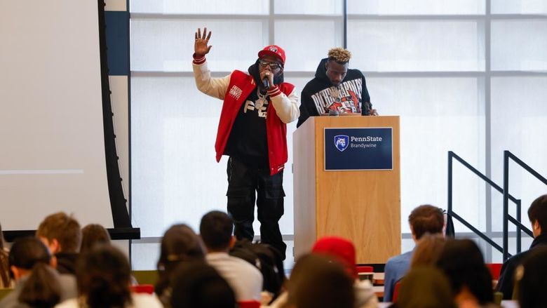 Philadelphia Freeway and DJ Crazy on stage with a large crowd of high schoolers