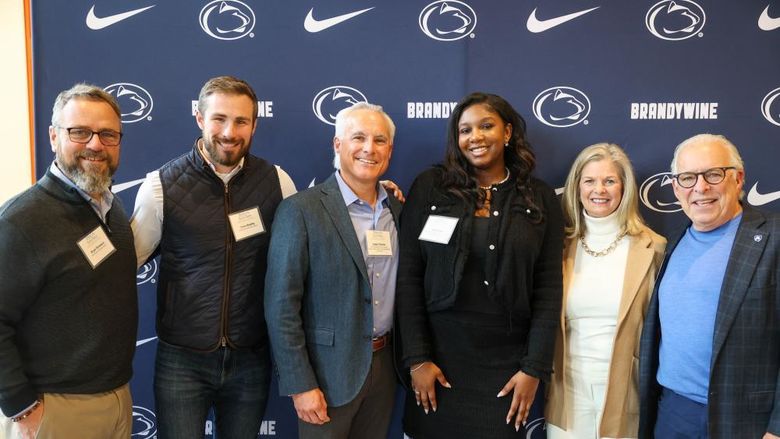 student with advisory board members pose for a photo