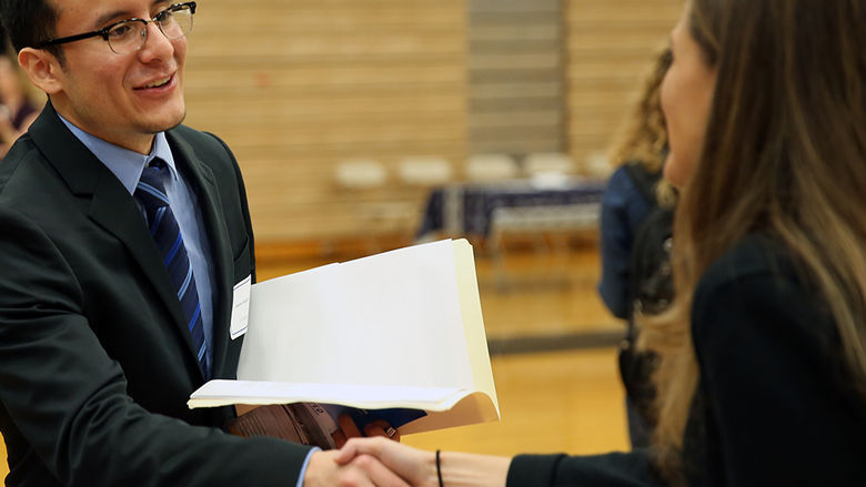 student shaking hands with a potential employer
