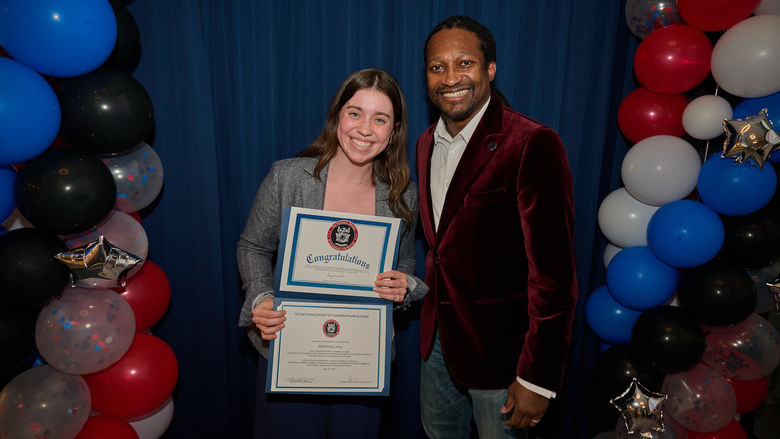 woman holding certificate and standing next to man