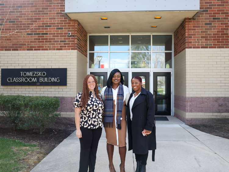 alumnae standing in front of Tomezsko Classroom Building