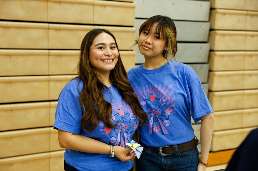 two girls posing, wearing mental health and wellness fair t-shirts